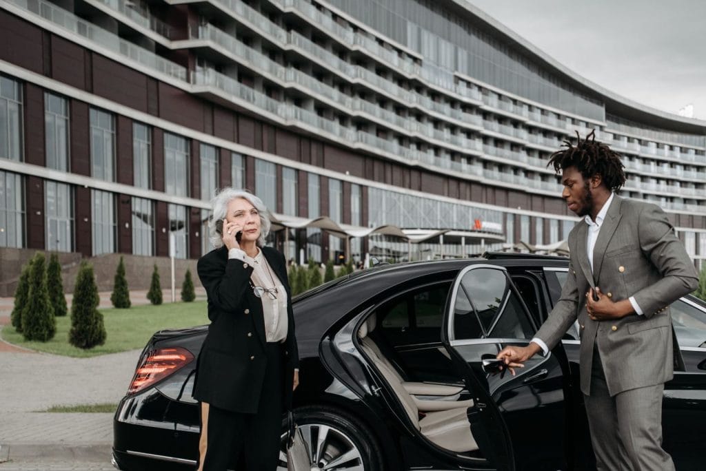 VIP chauffeur service driver holding the door of an executive Mercedes